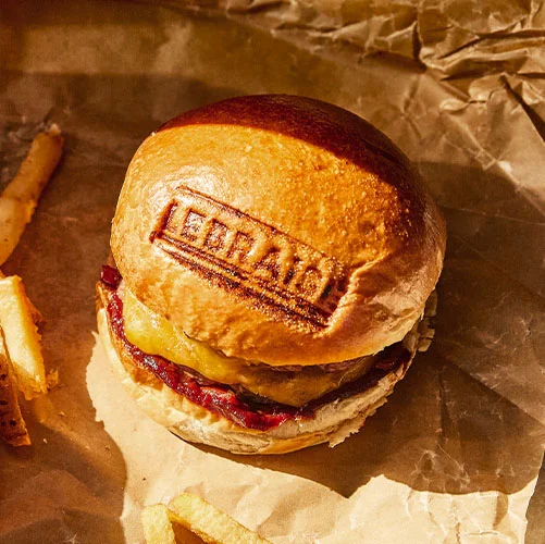 Le Braisé — burger signature et frites sur papier kraft